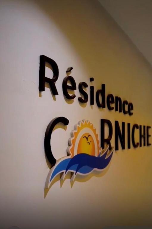 a sign on a wall with theres a logo on it at La corniche in Kenitra