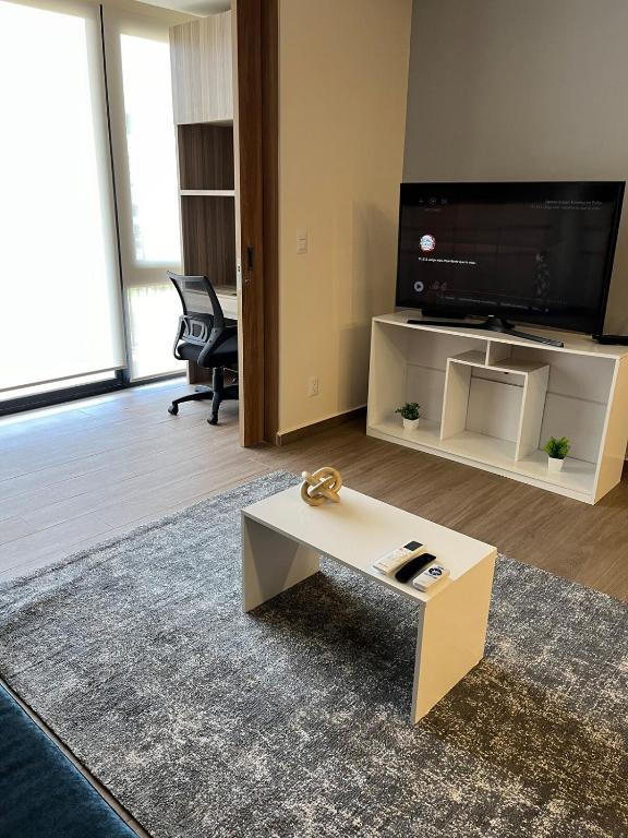 a living room with a coffee table and a flat screen tv at Executive Loft - Gym - Home Office - Zibatá in La Cañada