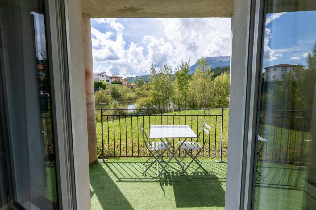 a view of a table and chairs on a balcony at Vue lac - T2 rénové - Parking - 4 pers in Gap