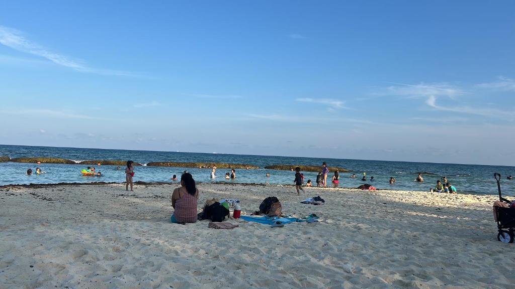 a group of people sitting on the beach at Xcalacoco Beach in Playa del Carmen