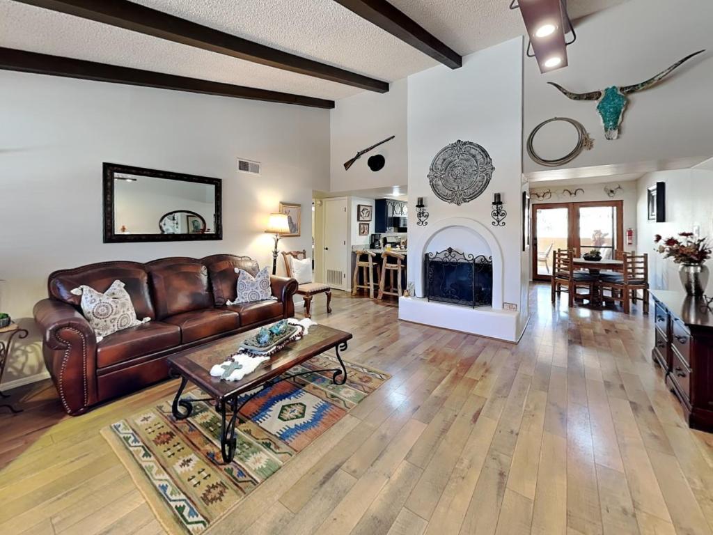 a living room with a leather couch and a fireplace at Billy The Kid at Aspen Run 4A in Ruidoso