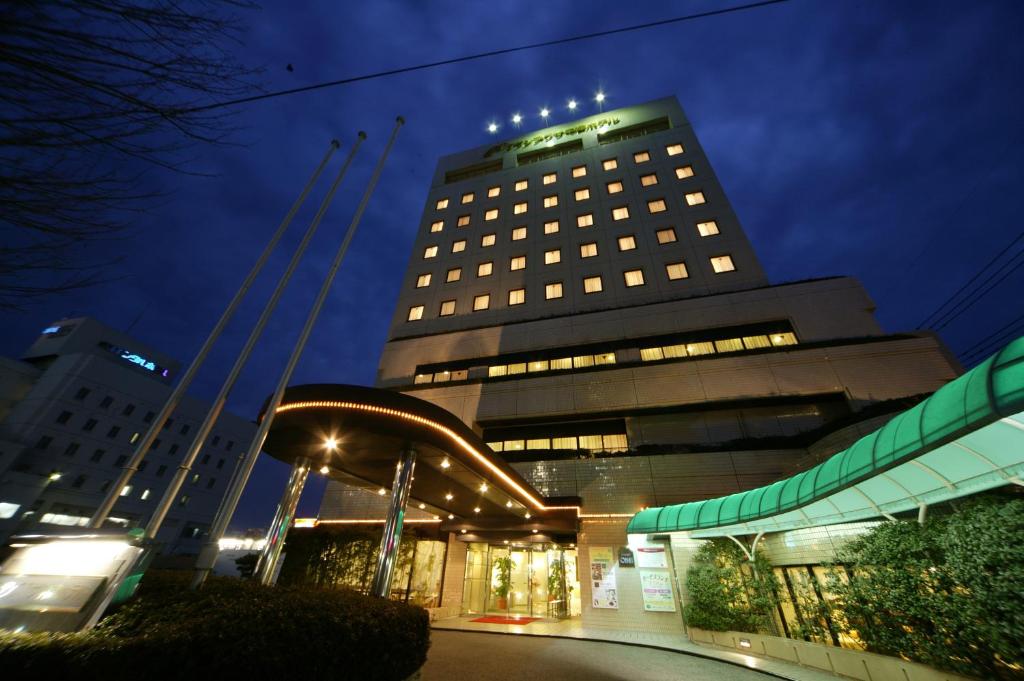 a tall building with lights in front of it at Grand Plaza Nakatsu Hotel in Nakatsu