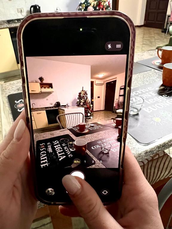 a person holding up a cell phone in a living room at Il sentiero per Assisi in Bastia Umbra