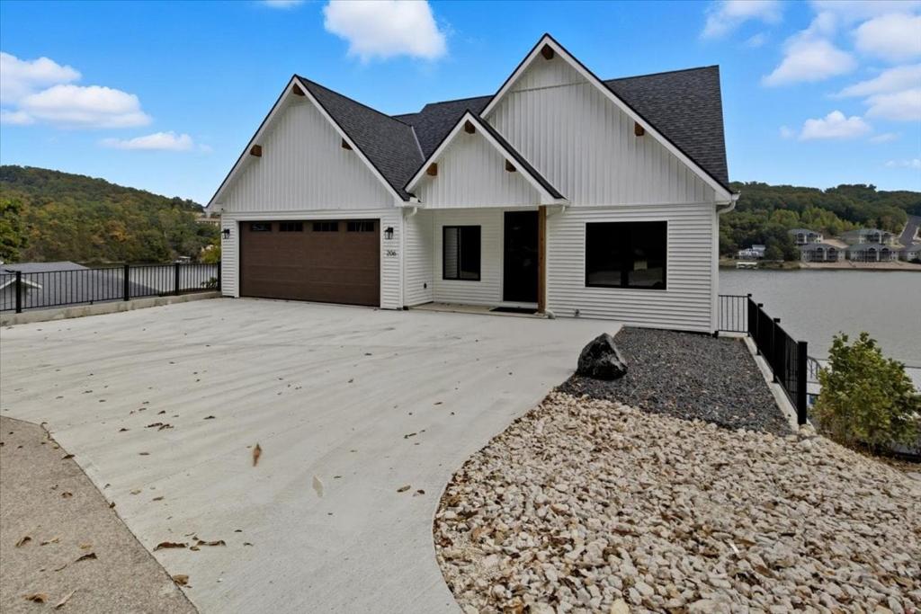 a large white house with a large driveway at Modern Lakefront Escape | The Twelve in Camdenton