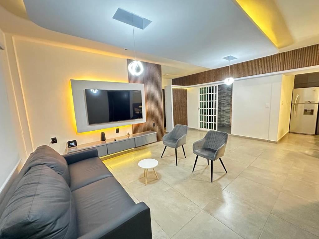 a living room with a couch and chairs and a tv at Casa Lujosa, Catemaco, Ubicación Céntrica in Catemaco