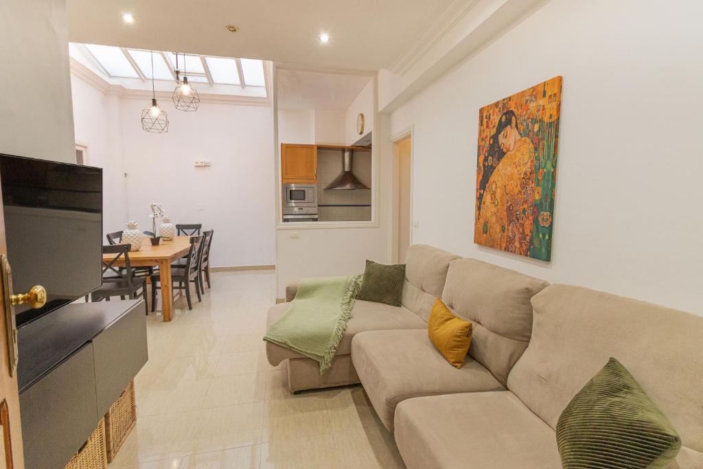 a living room with a couch and a dining room at El Laurel, Remote Work Friendly, City Center in Los Llanos de Aridane