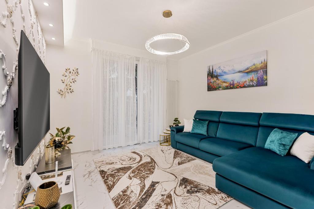 a living room with a blue couch and a tv at luxury apartament in Viareggio