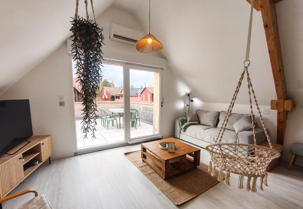 a living room with a couch and a swing at Mackenheim - Parenthèse détente en Alsace - Terrasse & Parking in Mackenheim