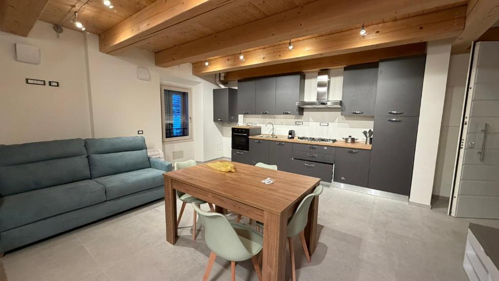 a kitchen and living room with a table and a couch at Forlì City Residence in Forlì