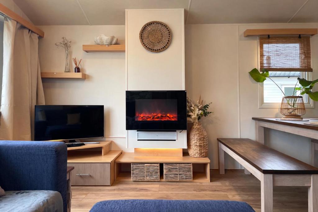 a living room with a fireplace in the wall at Rockley Park - Coral in Poole