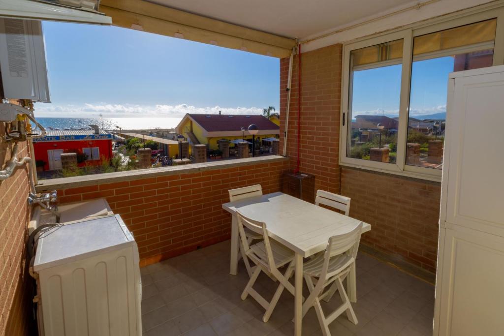 a kitchen with a table and chairs and a large window at Casa Onde & Tramonti in Marina di Grosseto