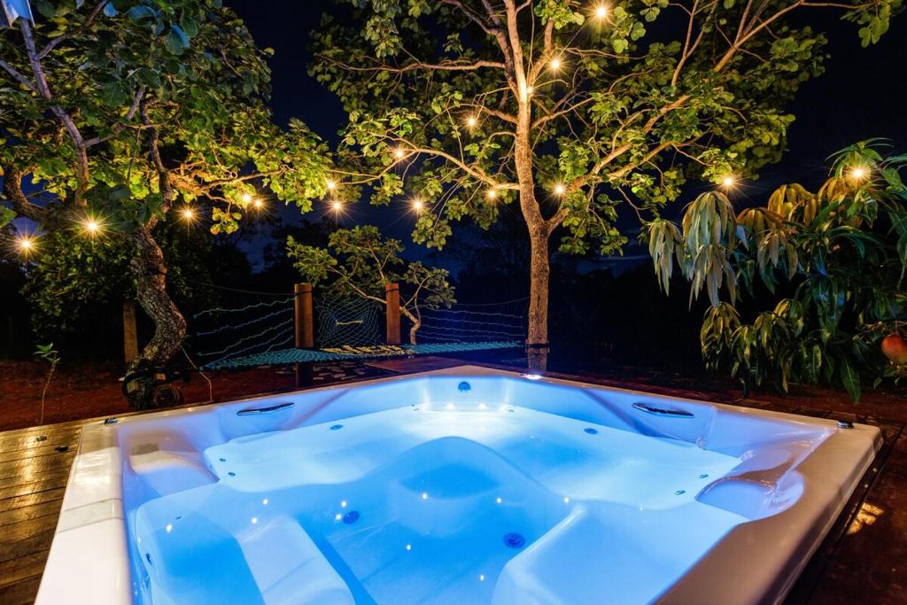 a jacuzzi tub in a garden at night at Chalé com hidro em meio a natureza in Brasília