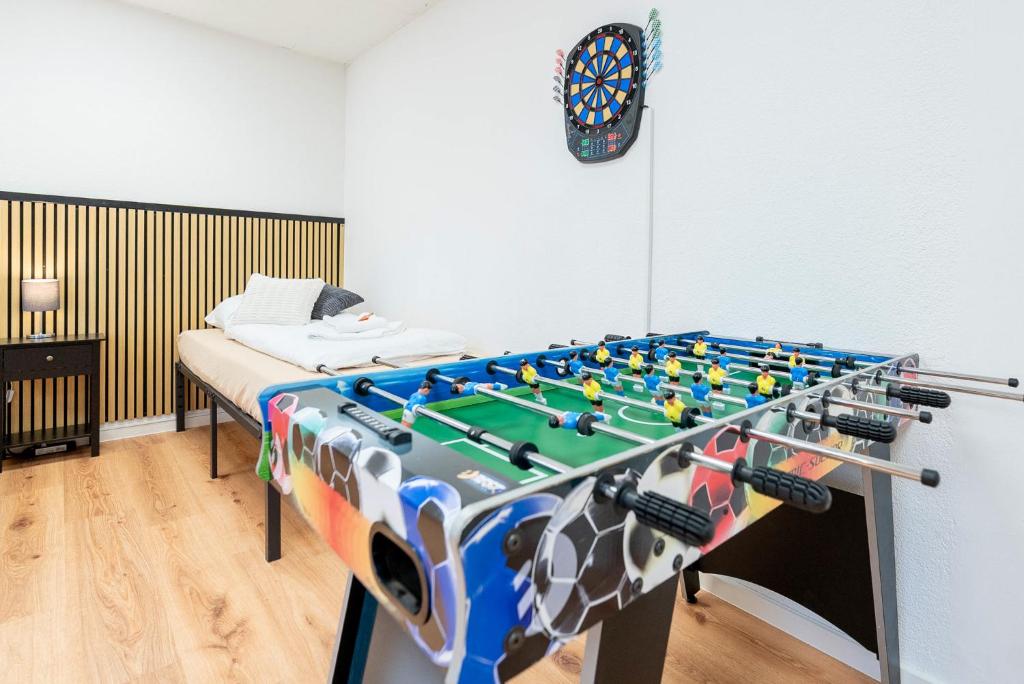 a room with a foosball table in front of a bed at Orange Suite Schliengen 2 in Schliengen