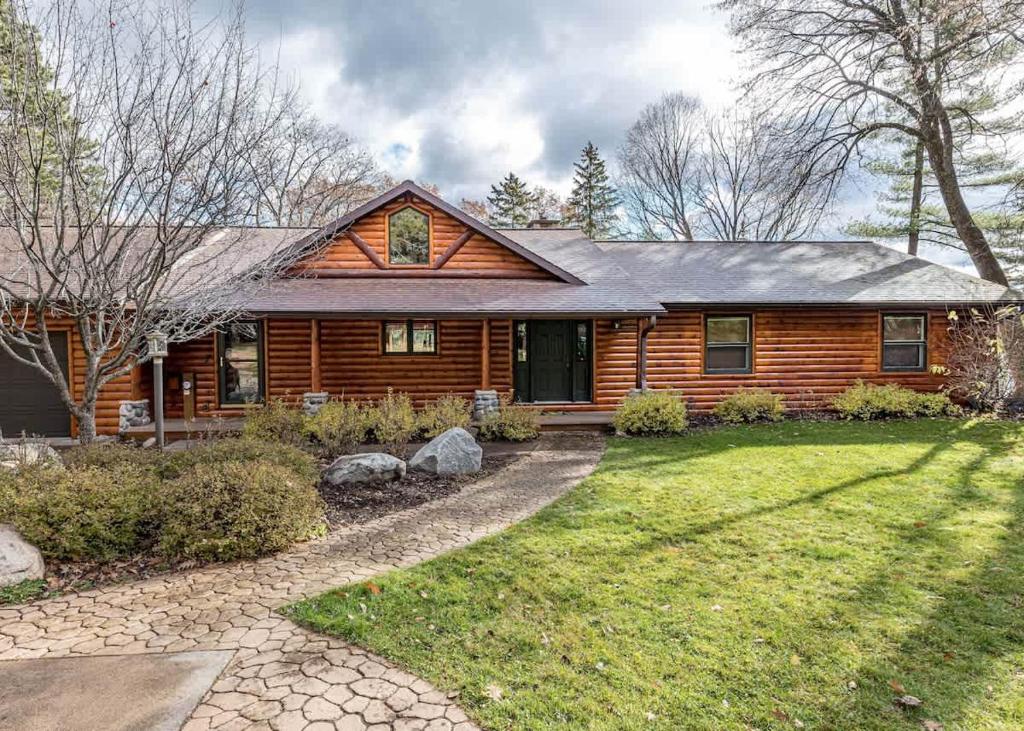 a log home with a yard and a house at Big Arbor Pines Family friendly in Woodruff