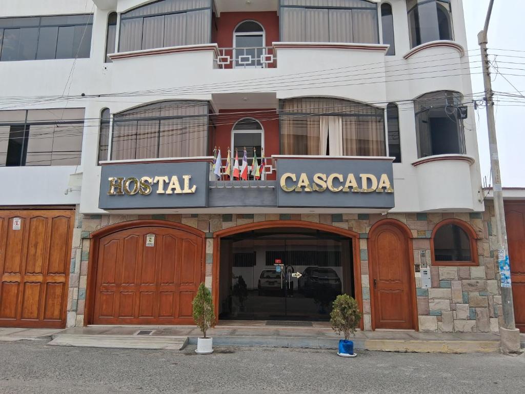 a hotel with wooden doors in front of a building at Hospedaje La Cascada in Tacna