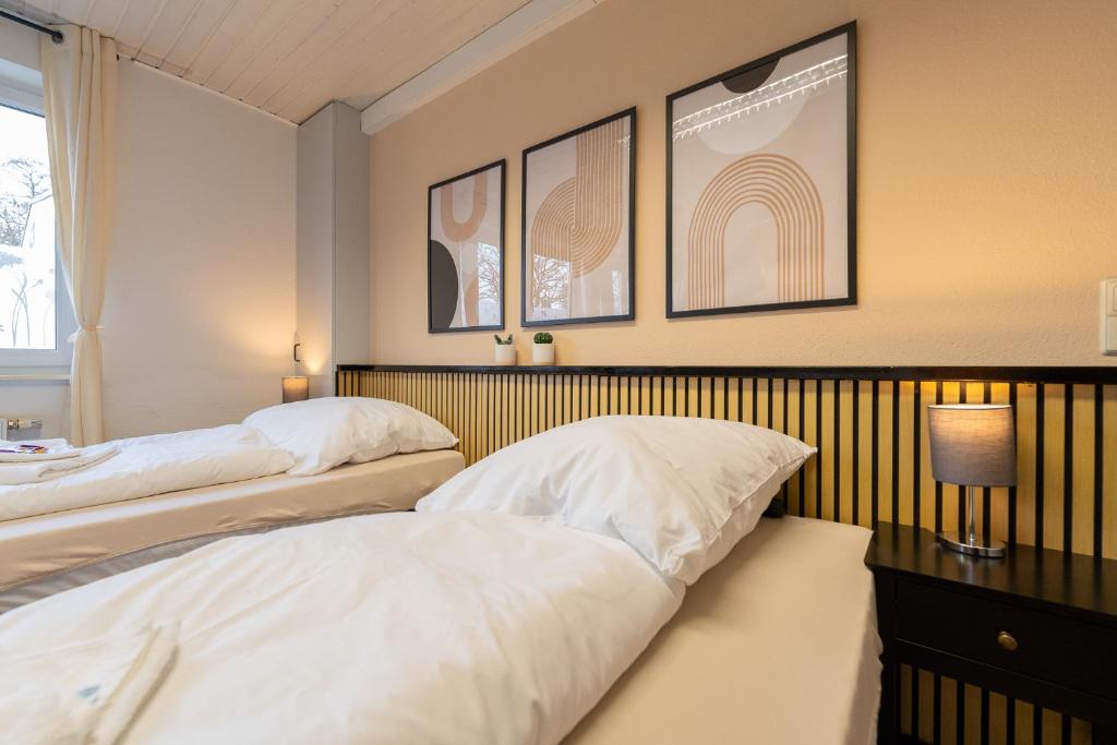 a bedroom with two beds and a table with a lamp at Orange Suite Schliengen 1 in Schliengen
