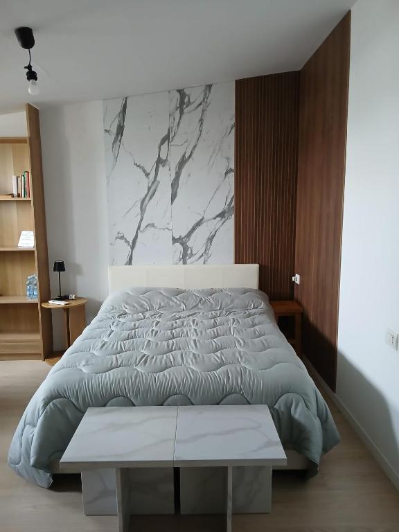 a bedroom with a large bed and a marble wall at Bovisa home in Milan