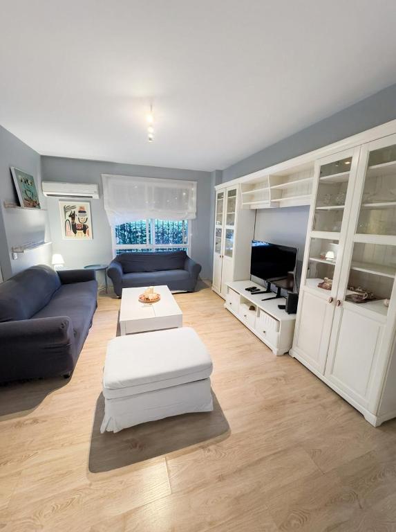a living room with a couch and a tv at Sevilla Family House - La casa de Marta in Montequinto