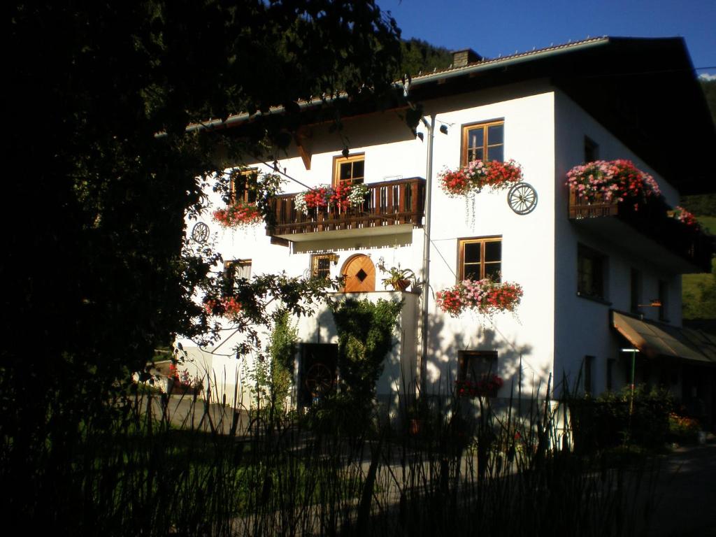 ein weißes Haus mit Blumenkästen drauf in der Unterkunft Haus Kathrein in Fliess