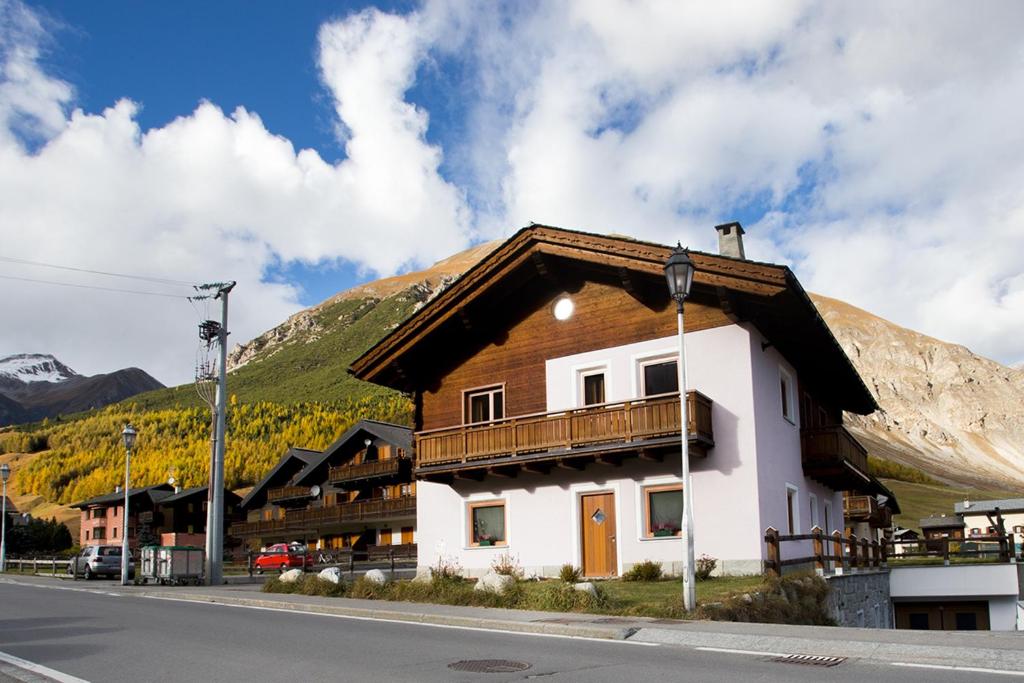 ein Gebäude an der Seite einer Straße mit einem Berg in der Unterkunft Appartamenti Anna & Kim in Livigno