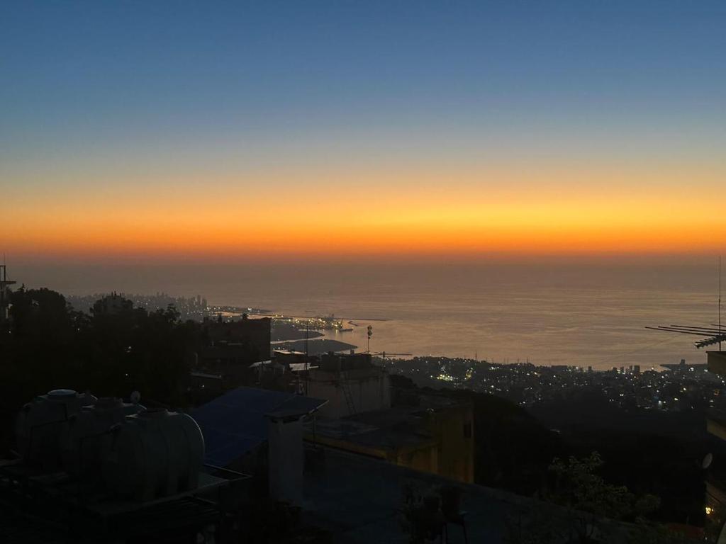 a view of a city at sunset at Mini 1BR Studio Central Broumana with Sea View in Broummana