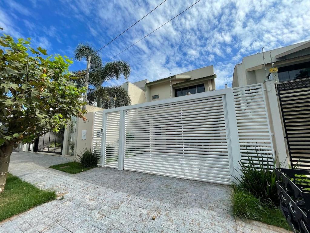 a white privacy fence in front of a house at Sobrado Premium - Zona Sul in Maringá