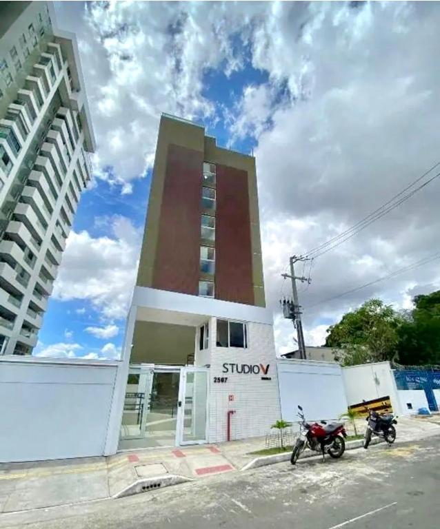 a building with two motorcycles parked in front of it at Studio V Ininga in Teresina