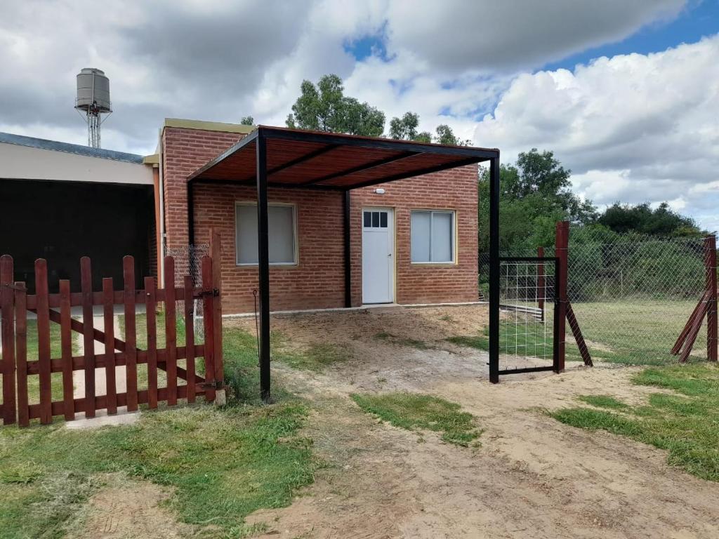 a building with a fence and a basketball hoop at Casita Rosa II in San José