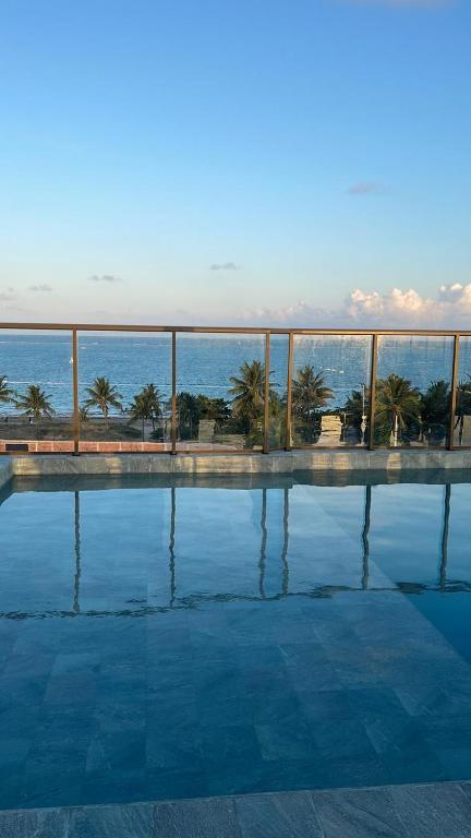 a swimming pool with a view of the ocean at Conforto e Sofisticação à Beira Mar in Cabedelo