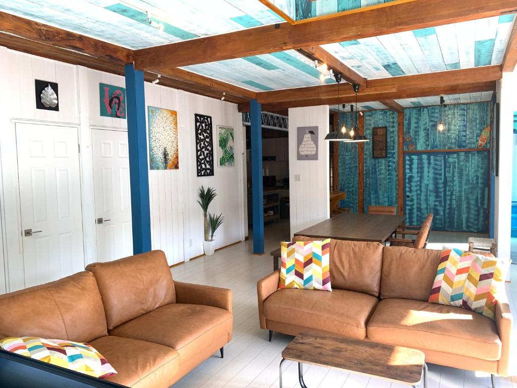 a living room with a couch and a table at Aqua Beach House Sotoura - 1min walk to Sotoura Beach! in Shimoda