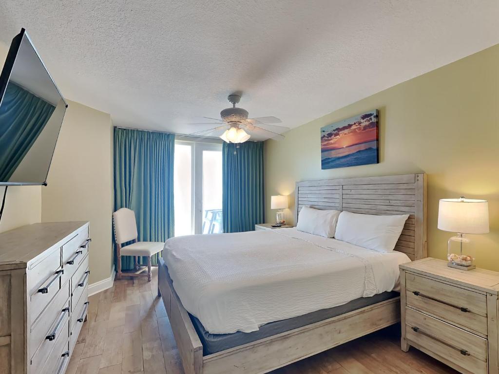 a bedroom with a large bed and a television at Sea Dunes #401 in Fort Walton Beach