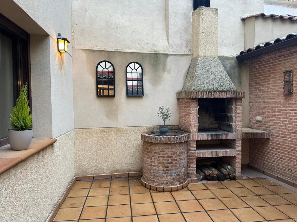 a patio with a brick fireplace in a house at Casa Rural Caraca in Driebes