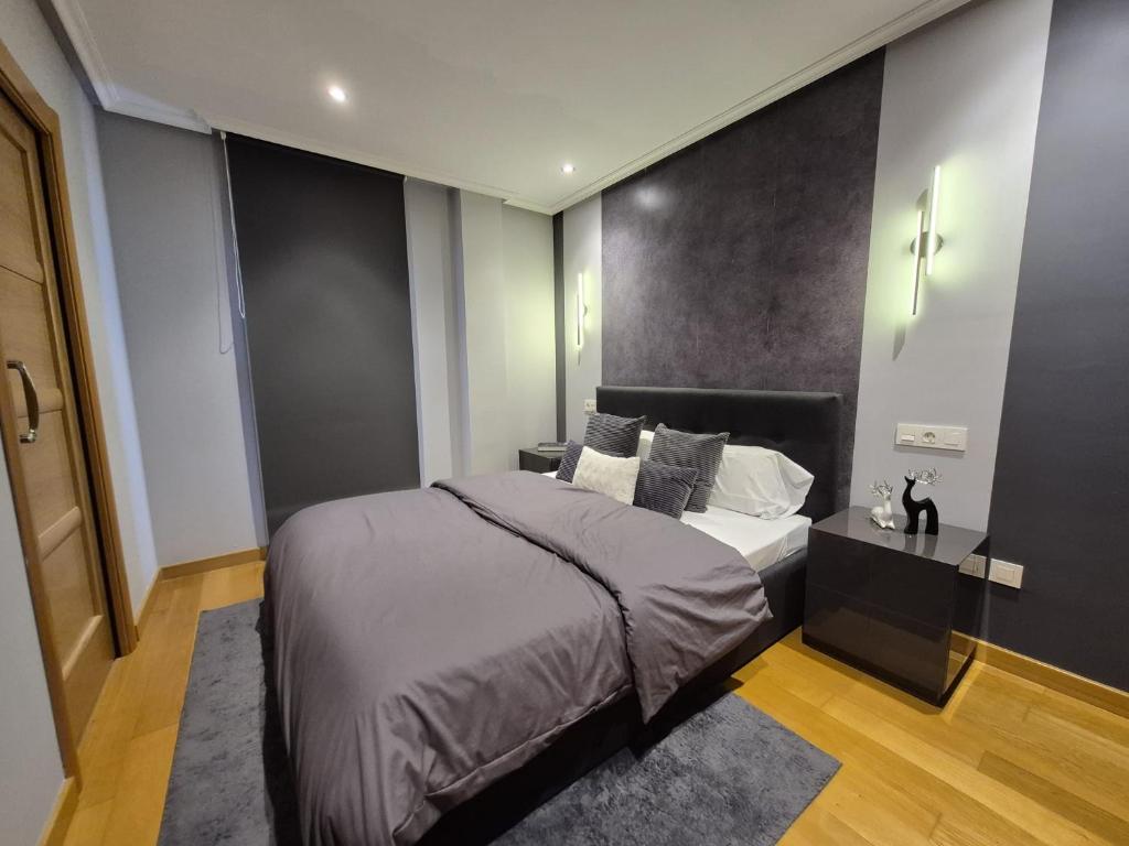 a bedroom with a bed and a black wall at Mercurio Blanco-Zona Catedral in León