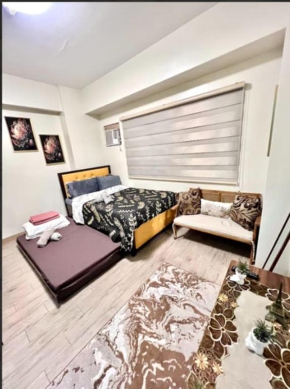 a bedroom with a bed and a couch in it at 3ff Megaworld, One Regis in Bacolod
