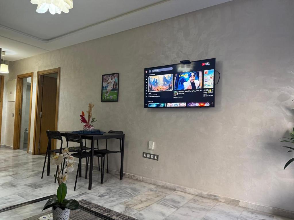 a living room with a television on the wall at Appartement de lux avec piscine in Mohammedia