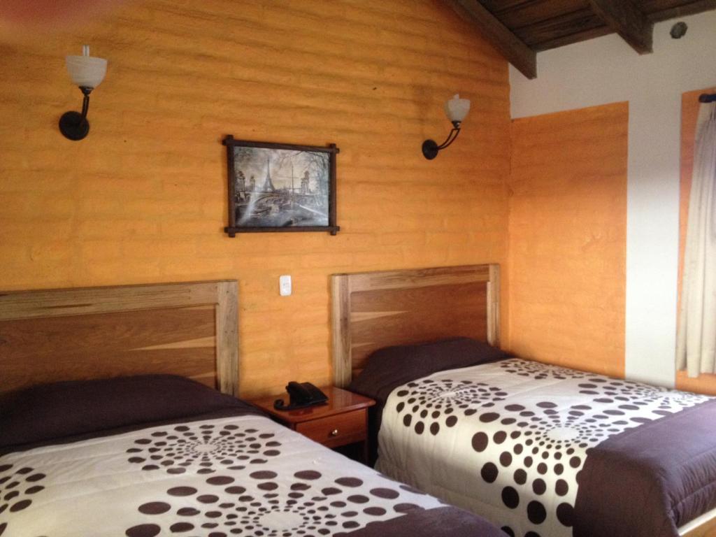 Postel nebo postele na pokoji v ubytování Hotel y Hosteria Natabuela
