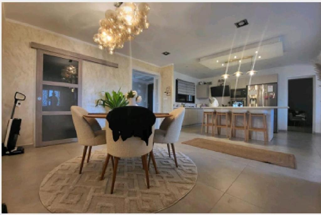 a dining room with a table and chairs and a kitchen at Jolie villa in Piolenc