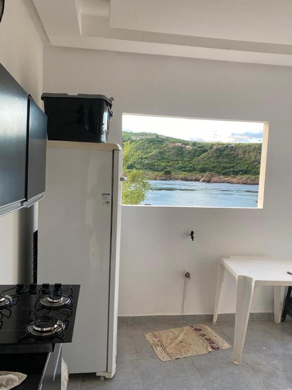 a kitchen with a stove and a window at Chalé Velho Chico in Canindé de São Francisco
