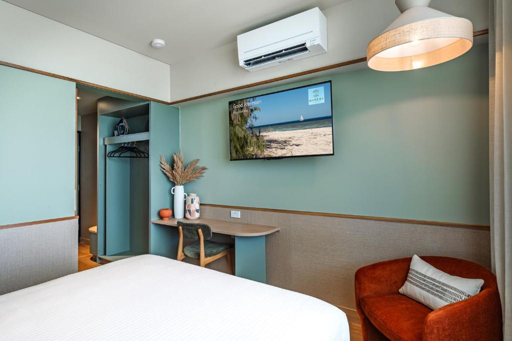 a bedroom with a bed and a desk and a tv at The Queens Hotel Gladstone in Gladstone