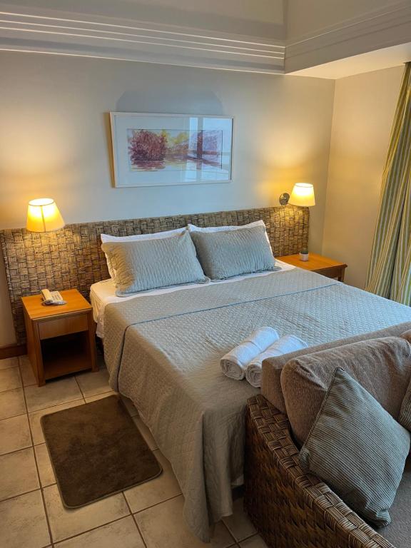 a bedroom with a large bed with two towels on it at Flat Tropical Hotel Com Varanda Vista Espetacular in Manaus