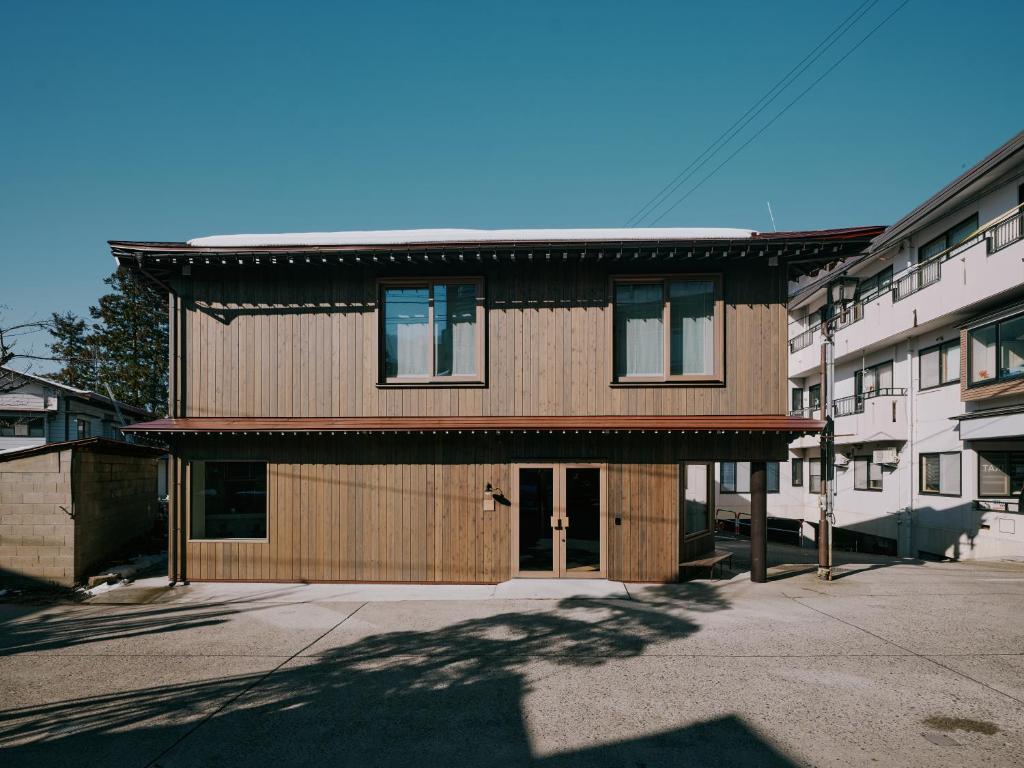 a large wooden house with a roof at mont - Nozawa Onsen Ski Resort in Nozawa Onsen