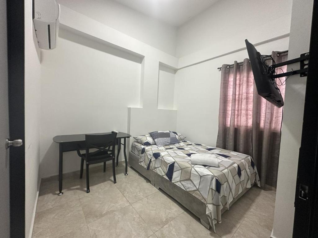 a bedroom with a bed and a table and a desk at San Luis Apartamento 302 Cúcuta in Cúcuta