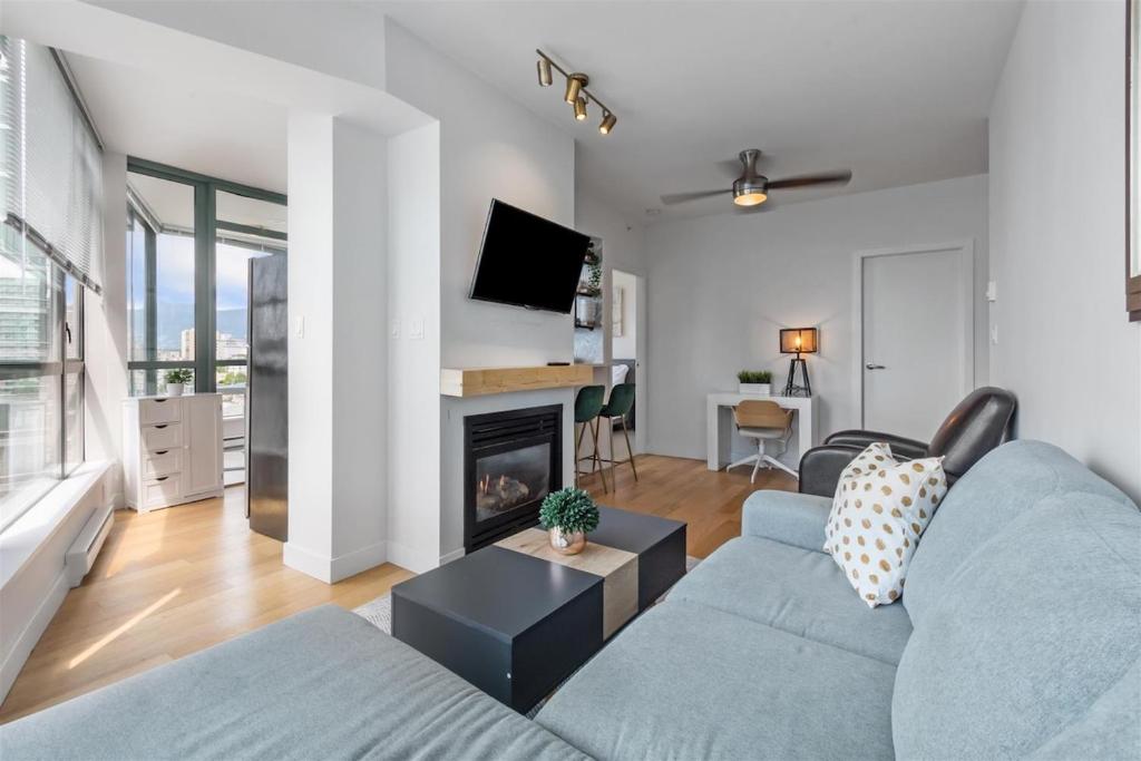 a living room with a couch and a fireplace at Sub-Penthouse view condo in Downtown in Vancouver