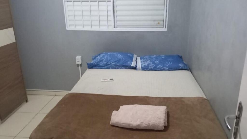 a bed in a room with a pillow on it at mendes in Água Boa