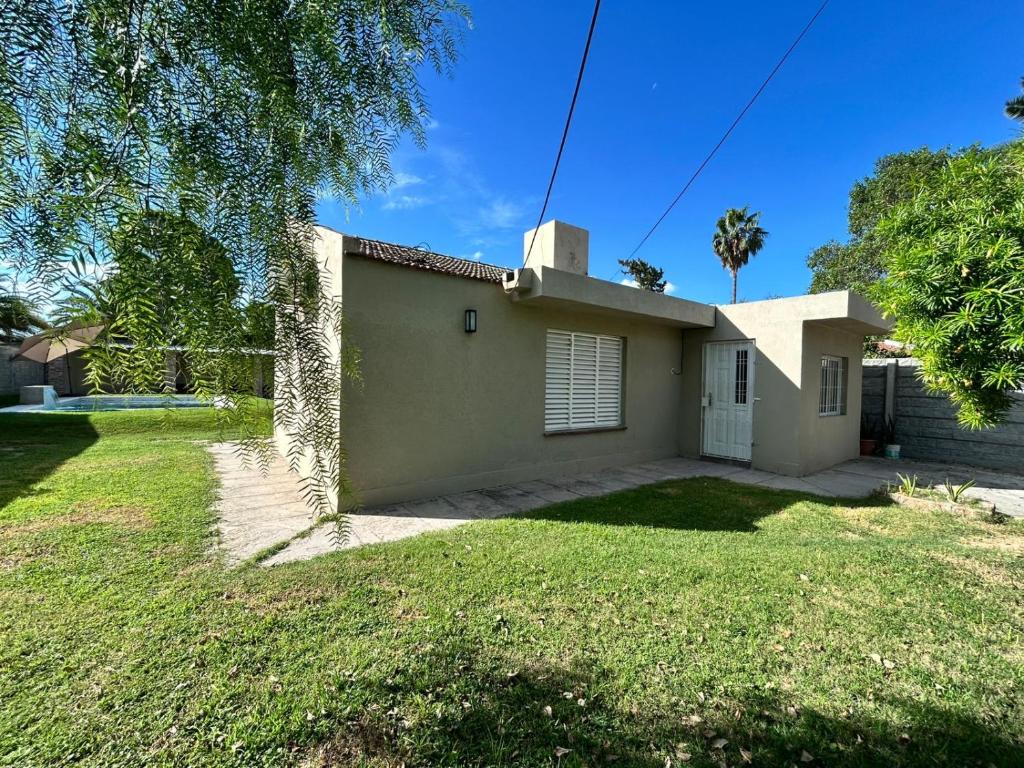 a house with a grass yard in front of it at Kusi 51 in La Banda
