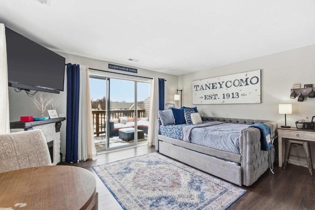 a bedroom with a bed and a tv and a table at TaneyCoMo Topia Quaint Studio in Branson
