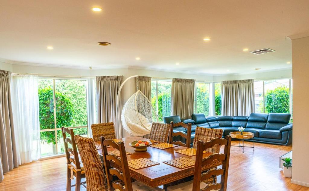 a living room with a couch and a table and chairs at Brightside , Great family home near Airport in Craigieburn