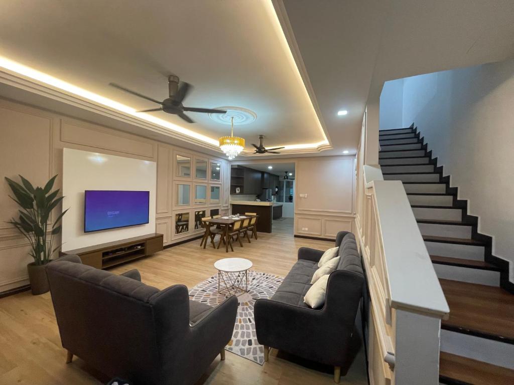 a living room with a couch and a tv and stairs at Hm home 2 in Sepang