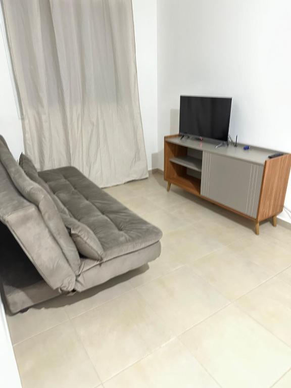 a living room with a couch and a tv at Vila Estrela in Ponta Grossa