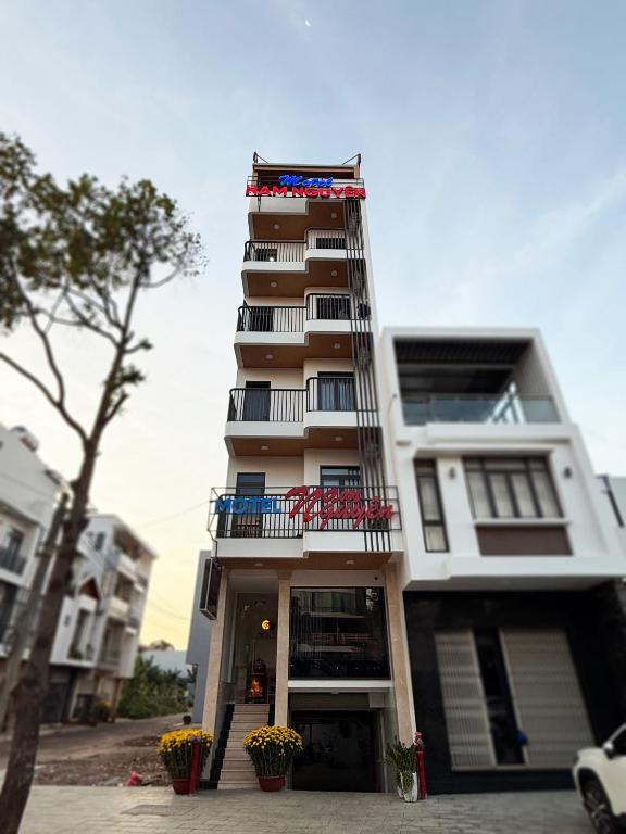 a tall white building with a balcony on it at Motel Nam Nguyên in Buôn Kô Sir
